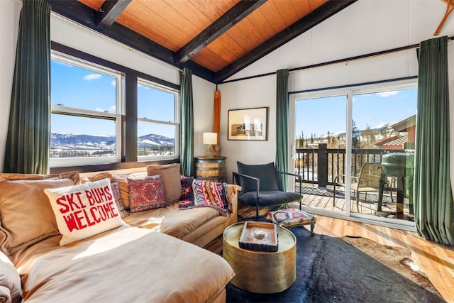 living area featuring a mountain view, wood ceiling, lofted ceiling with beams, and wood finished floors