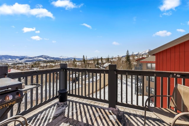 snow covered deck featuring a mountain view