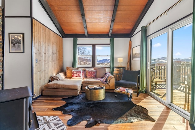 living area featuring lofted ceiling with beams, wood finished floors, and a mountain view