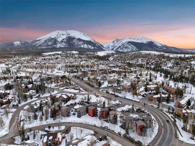 snowy aerial view with a mountain view and a residential view