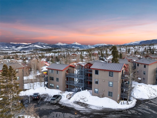 snowy aerial view with a residential view and a mountain view