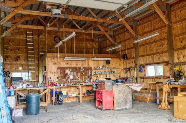 interior space featuring a workshop area, a garage door opener, and wood walls