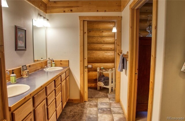 bathroom featuring rustic walls and vanity