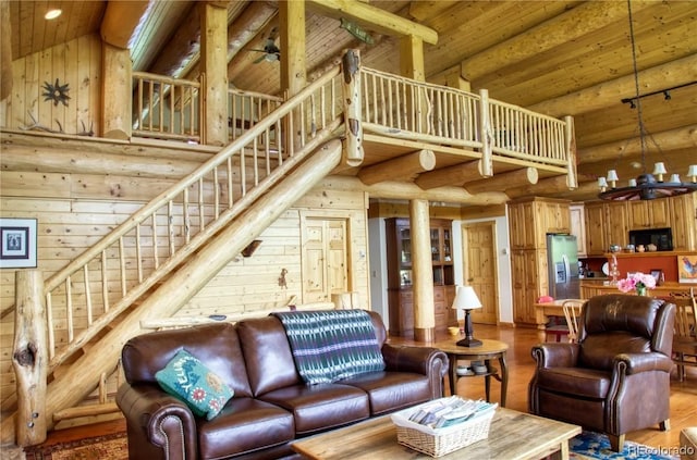 living room featuring rustic walls, hardwood / wood-style floors, a towering ceiling, and wooden ceiling