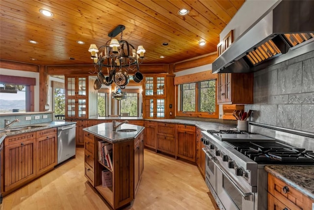 kitchen featuring appliances with stainless steel finishes, decorative light fixtures, sink, a center island, and exhaust hood