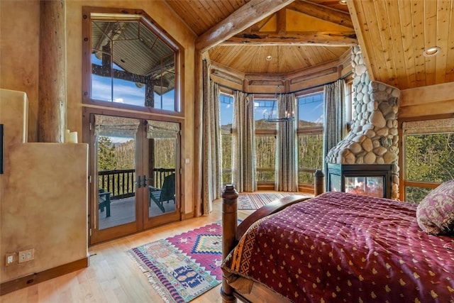 bedroom featuring a fireplace, light hardwood / wood-style flooring, access to exterior, wooden ceiling, and french doors