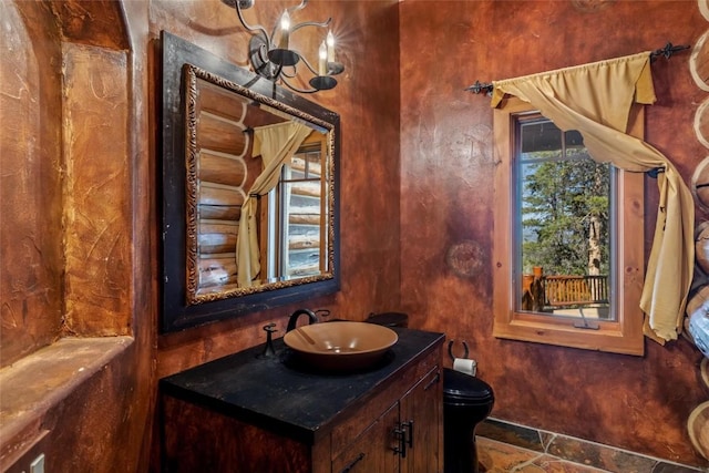 bathroom with vanity, toilet, and rustic walls