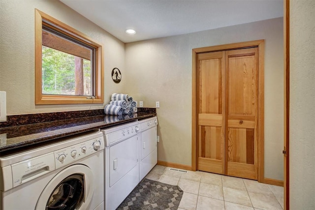 laundry area featuring separate washer and dryer and light tile patterned floors