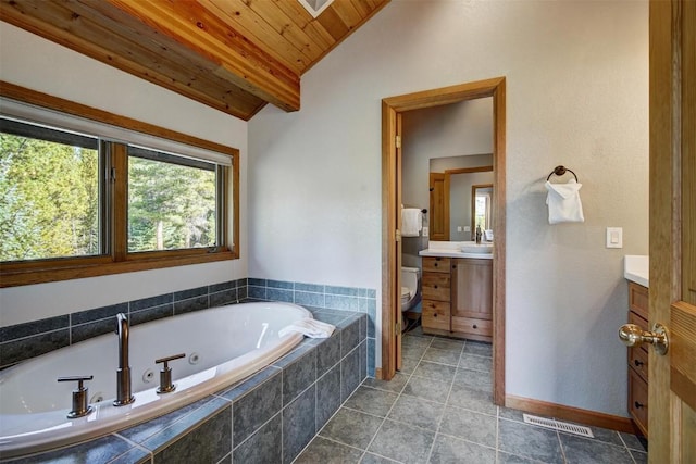 bathroom featuring vanity, vaulted ceiling, a relaxing tiled tub, toilet, and wood ceiling