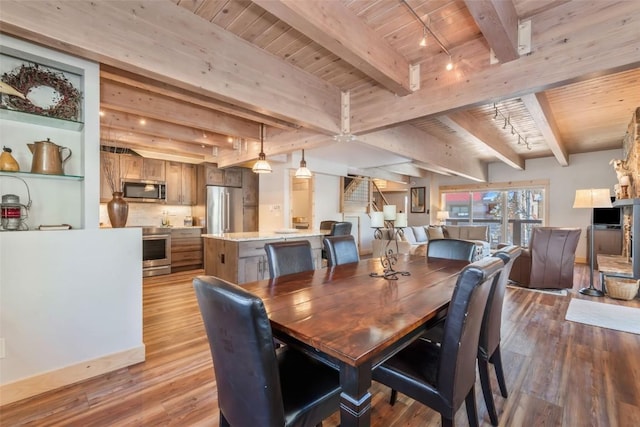 dining space with rail lighting, light wood-type flooring, beamed ceiling, and wood ceiling