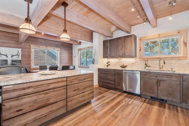 kitchen featuring beamed ceiling, stainless steel dishwasher, sink, decorative light fixtures, and light hardwood / wood-style flooring