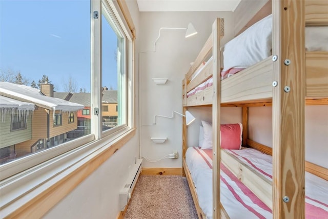 carpeted bedroom featuring baseboard heating and multiple windows