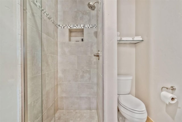 bathroom with toilet and tiled shower