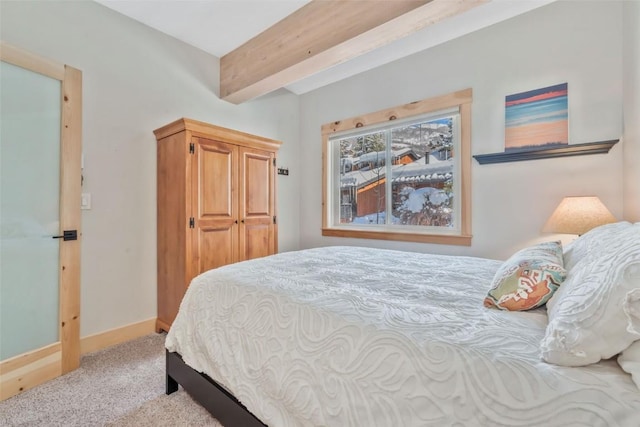 carpeted bedroom with beam ceiling