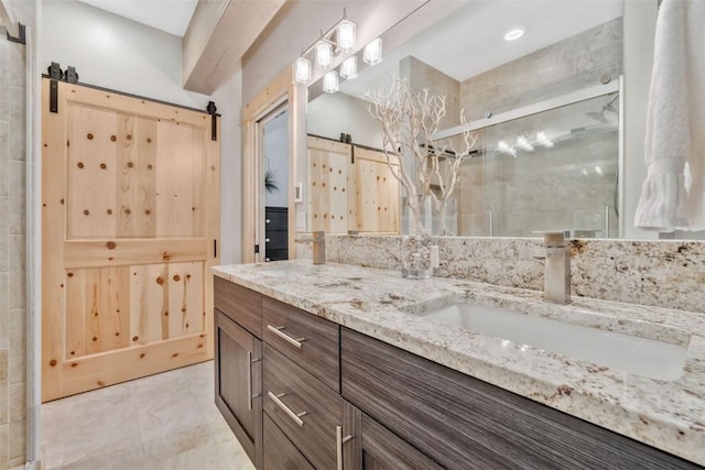 bathroom with a shower with shower door and vanity