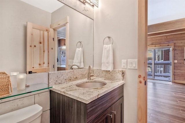 bathroom with wood-type flooring, toilet, and vanity