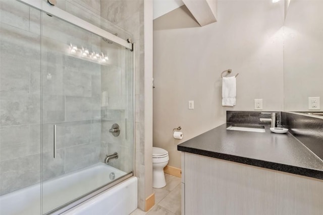 full bathroom with sink, shower / bath combination with glass door, toilet, and tile patterned flooring