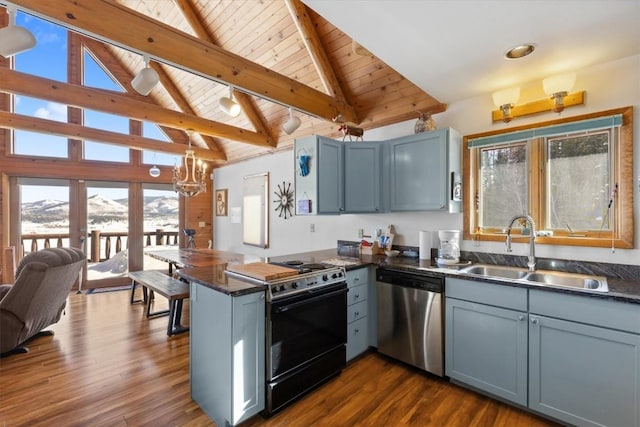 kitchen featuring stainless steel dishwasher, gas range, dark countertops, and a sink