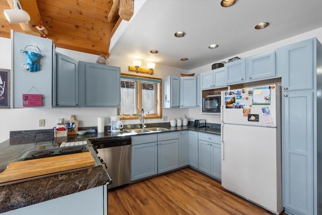 kitchen featuring wood finished floors, freestanding refrigerator, a sink, black microwave, and dishwasher