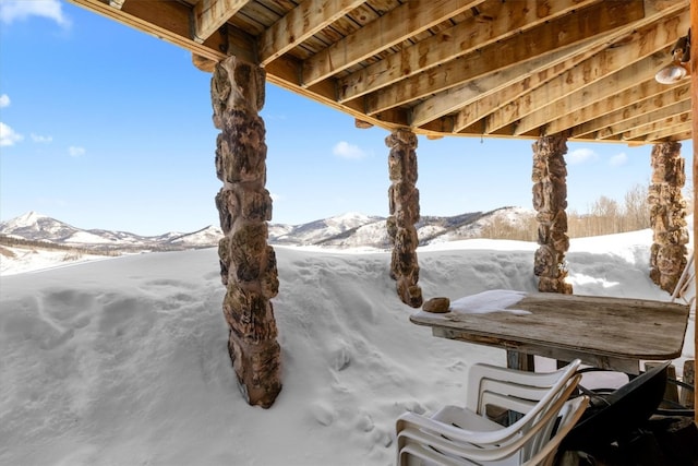 snow covered patio featuring a mountain view