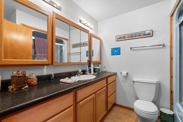 bathroom featuring vanity, baseboards, a shower, tile patterned floors, and toilet