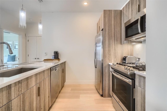 kitchen with sink, hanging light fixtures, stainless steel appliances, tasteful backsplash, and light wood-type flooring