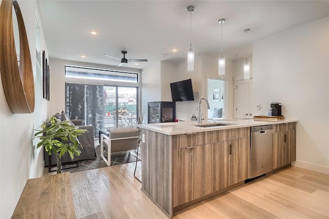 kitchen featuring kitchen peninsula, light wood-type flooring, stainless steel dishwasher, ceiling fan, and sink