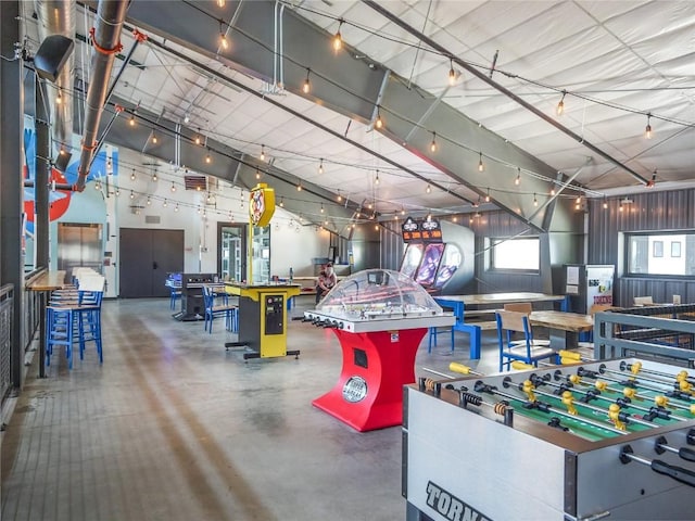 rec room with concrete flooring and a towering ceiling