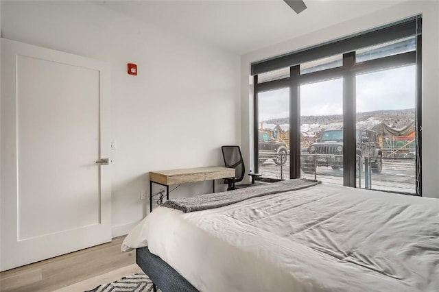 bedroom with light wood-type flooring, access to outside, and ceiling fan