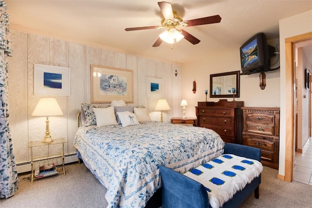 bedroom featuring ceiling fan, wooden walls, carpet floors, and a baseboard heating unit