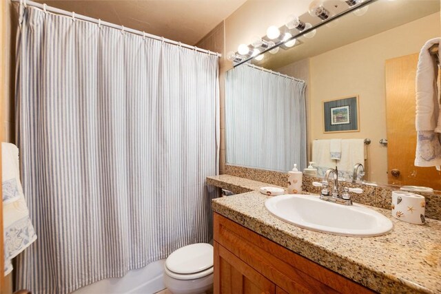 bathroom featuring vanity, toilet, and walk in shower