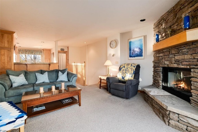 living room with a stone fireplace and carpet floors