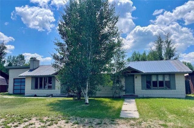 ranch-style house featuring an attached garage, metal roof, a chimney, and a front lawn