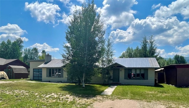 ranch-style house with a garage, metal roof, a chimney, and a front lawn