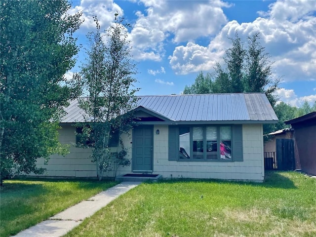 ranch-style house featuring metal roof and a front yard