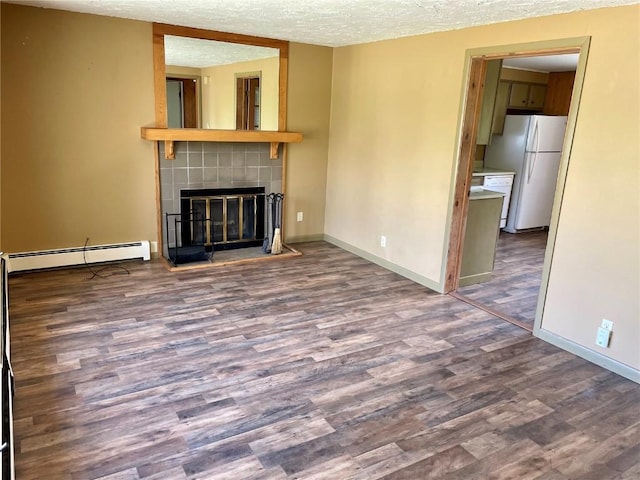 unfurnished living room featuring a textured ceiling, a baseboard heating unit, a fireplace, wood finished floors, and baseboards