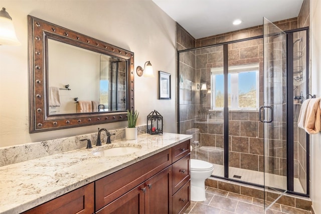 bathroom featuring tile patterned flooring, vanity, toilet, and a shower with door