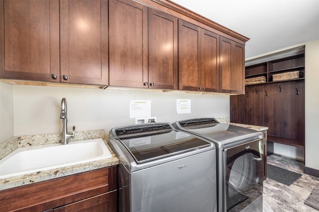 laundry area with washer and clothes dryer, cabinets, and sink