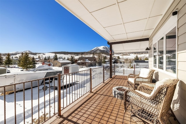 snow covered back of property with a mountain view