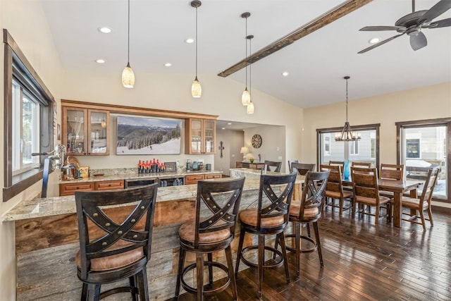 bar featuring pendant lighting, vaulted ceiling with beams, dark hardwood / wood-style floors, and light stone counters