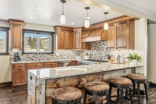 kitchen with kitchen peninsula, range, light stone counters, and custom exhaust hood