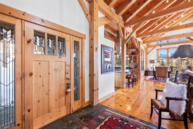 foyer entrance featuring high vaulted ceiling and beam ceiling