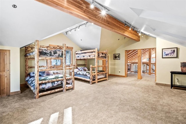 bedroom featuring track lighting, carpet floors, and lofted ceiling with beams