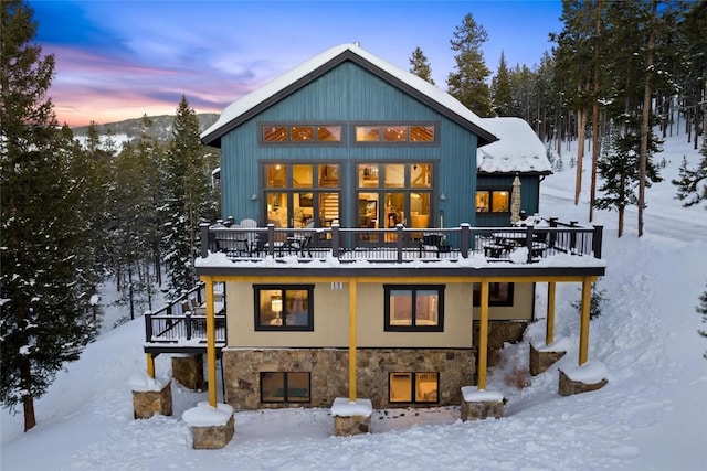 snow covered property with a wooden deck