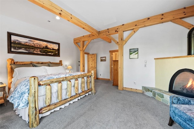 bedroom with carpet, beam ceiling, and a stone fireplace