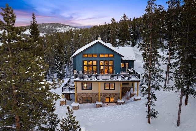 snow covered rear of property with a mountain view