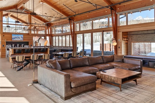 living room with wooden walls, wood ceiling, beamed ceiling, and high vaulted ceiling