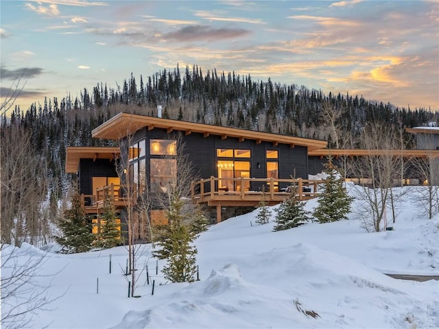 contemporary home with a deck and a forest view