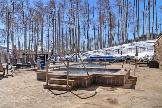 view of patio / terrace with a community hot tub and fence