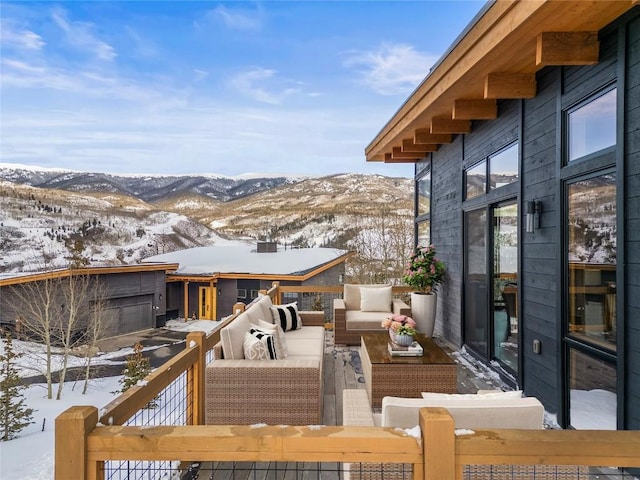 snow covered deck featuring a mountain view and an outdoor hangout area